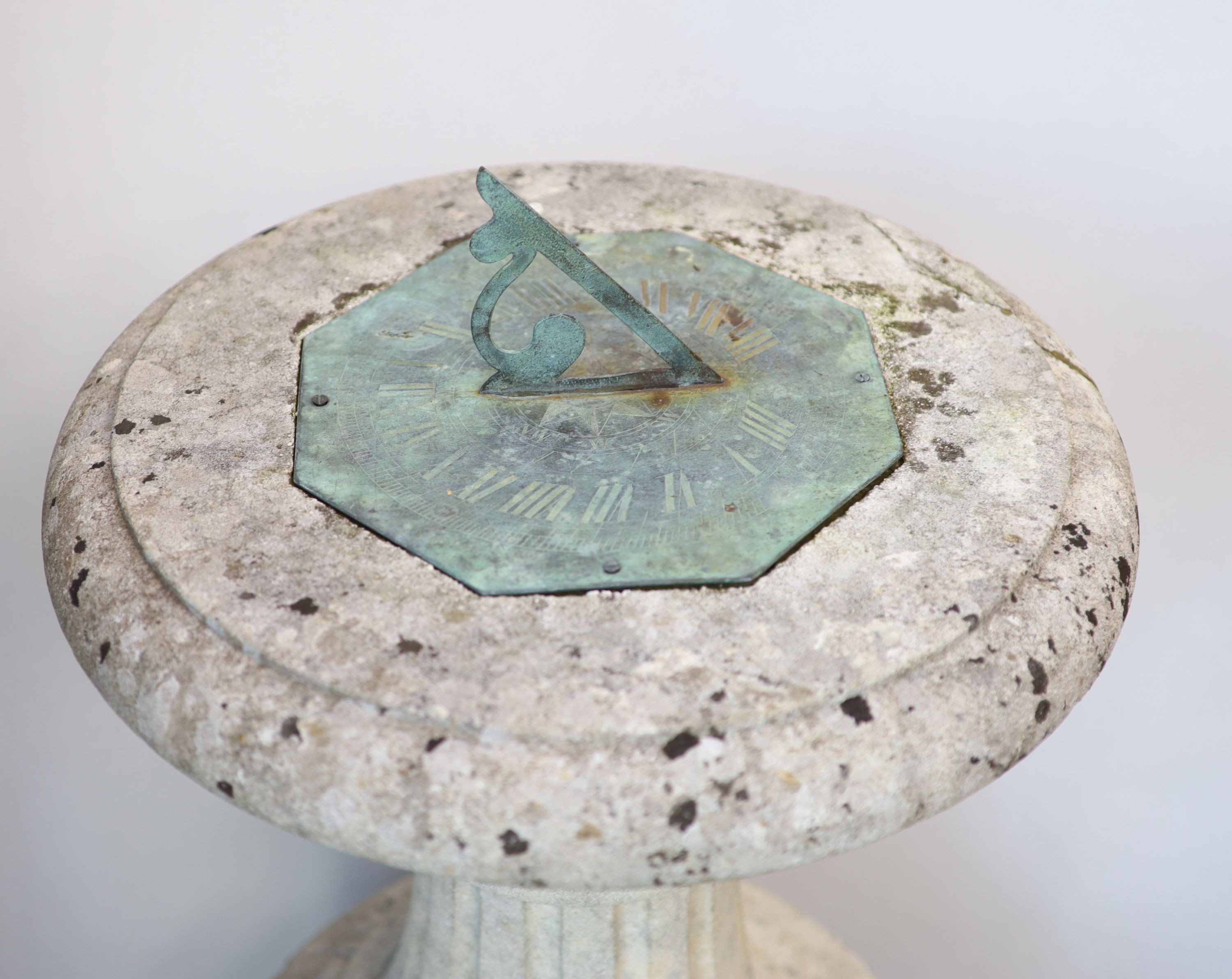 An Edwardian bronze sundial of octagonal form, on a carved stone base H 100cm. W 47cm.